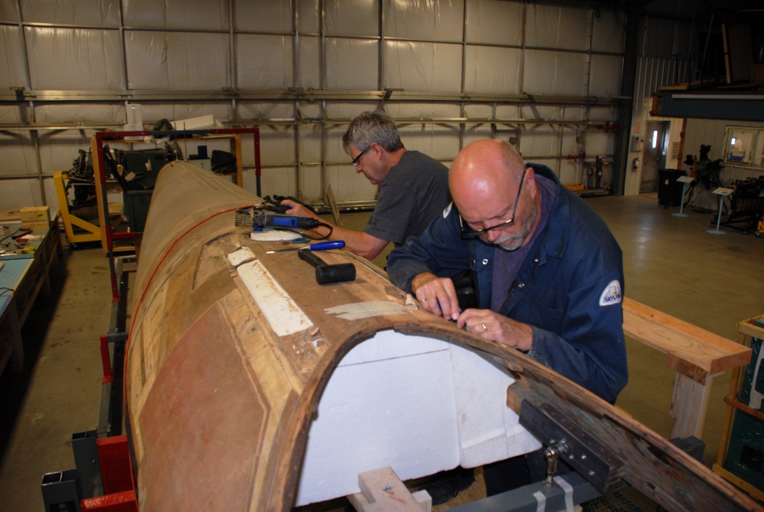 Working from the newly constructed scaffold, Brian and Andy tackle some of the delicate repairs on the port side upper fuselage.